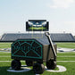 A black and teal wheeled cart with the text 'JUNGLE BOYZ' on the side, positioned on a green football field with stadium lights, bleachers, and a large screen in the background.