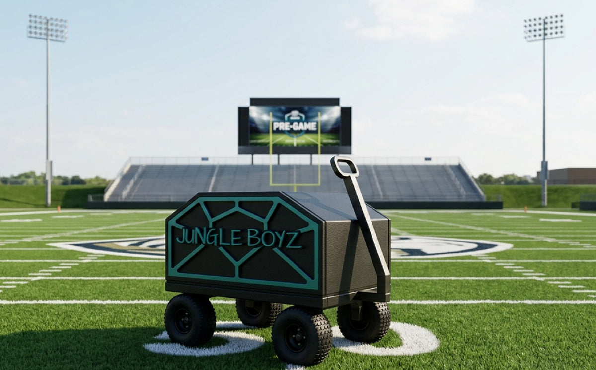 A black and teal wheeled cart with the text 'JUNGLE BOYZ' on the side, positioned on a green football field with stadium lights, bleachers, and a large screen in the background.